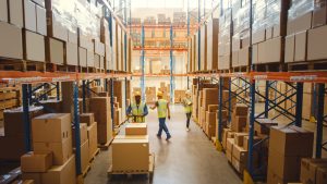 Pallet storage inside warehouse space in Wolverhampton with workers moving cargo for fulfilment. 