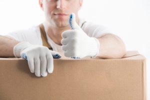 Delivery man wearing white gloves for two man home delivery services representing white glove services.