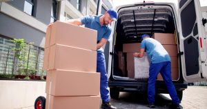 Two Man Home Delivery taking boxes out of back of truck and loading to take up stairs.