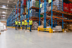 Warehouse in Stafford with workers walking past pallet storage racking systems and fulfilment services