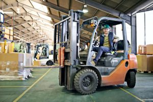 Warehouse worker operating forklift moving pallets in modern Liverpool warehouse for storage and fulfilment