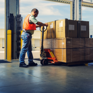 Warehouse worker moving pallet storage via forklift in Wrexham. 