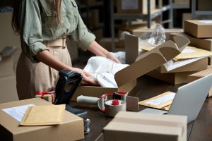 Worker doing pick and pack a fulfilment service in warehouse with labelling. 