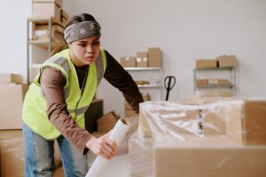 Worker doing labelling which is a value added service for a 3PL. 