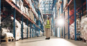 Warehouse worker walking through racked pallet stroage inside Dewsbury 3PL.