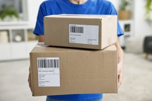 Man holding small packages from fulfilment centre in Sale. 