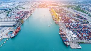 Aerial shot of container port backed up by ships and freight.