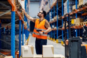 Warehouse worker doing pick and pack for ecommerce order fulfilment.