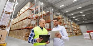 Warehouse workers stood in front of large racked pallet storage looking for warehouse space.