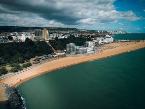 Folkestone from the coast with warehousing and 3PLs in the background of the beach.