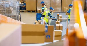 Warehouse workers on conveyor belt doing pick and pack for fulfilment near to London.