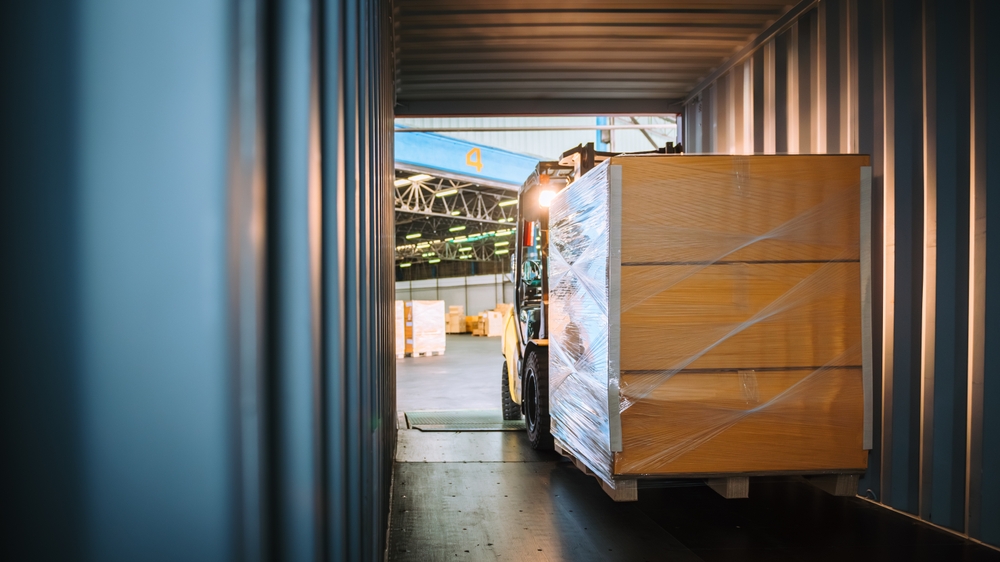Forklift putting parcels into a HGV outside loading dock for order fulfilment.