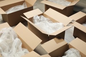 Open boxes for packages that are being used for fulfilment in a 3PL with bubble wrap and additional packaging inside.