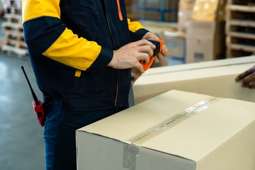 3PL worker placing labels and packing orders for fulfilment. 