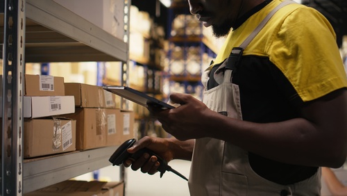 Warehouse worker scanning packages for pick and pack fulfilment. 
