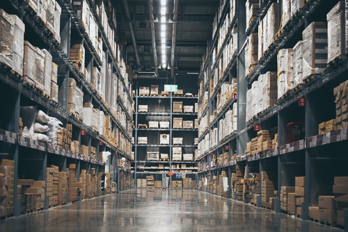 Aisle of racked pallet storage in warehouse space with some space for cartons. 